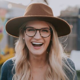 selective focus photography of smiling woman wearing brown hat